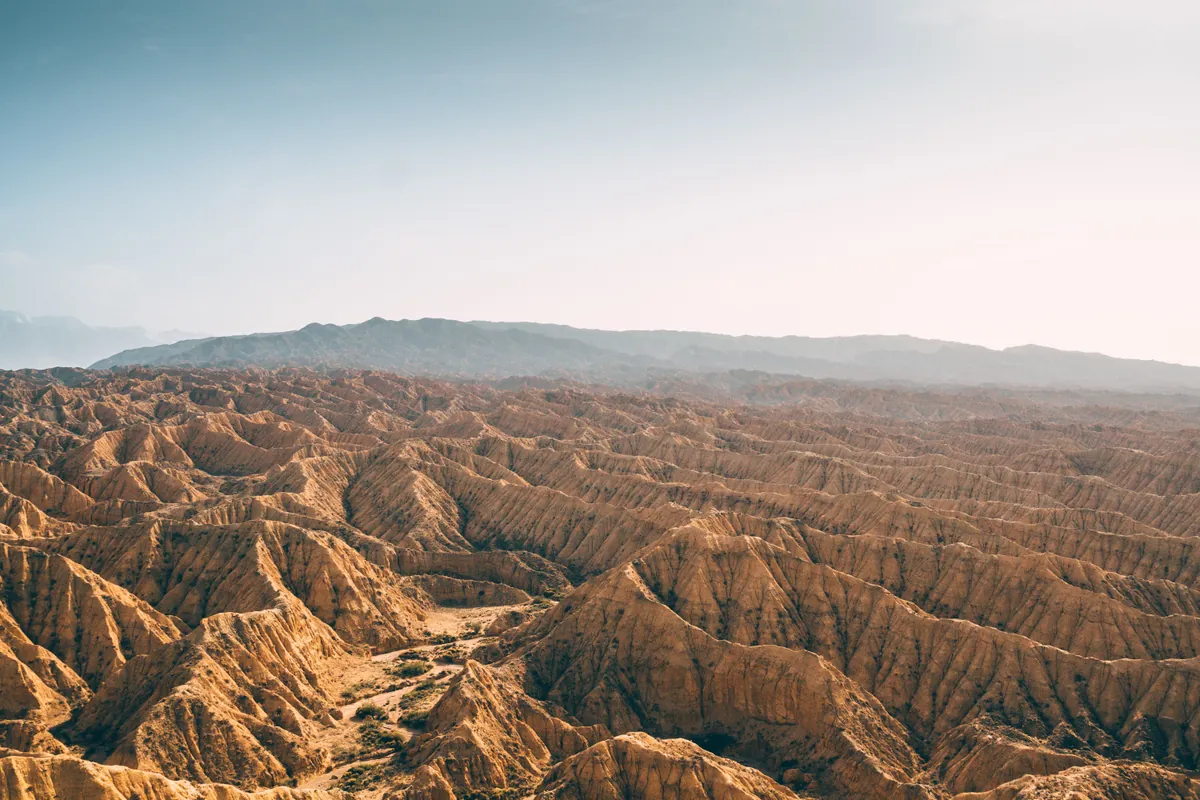 Aerial view of arid desert ridges and washes under a clear sky