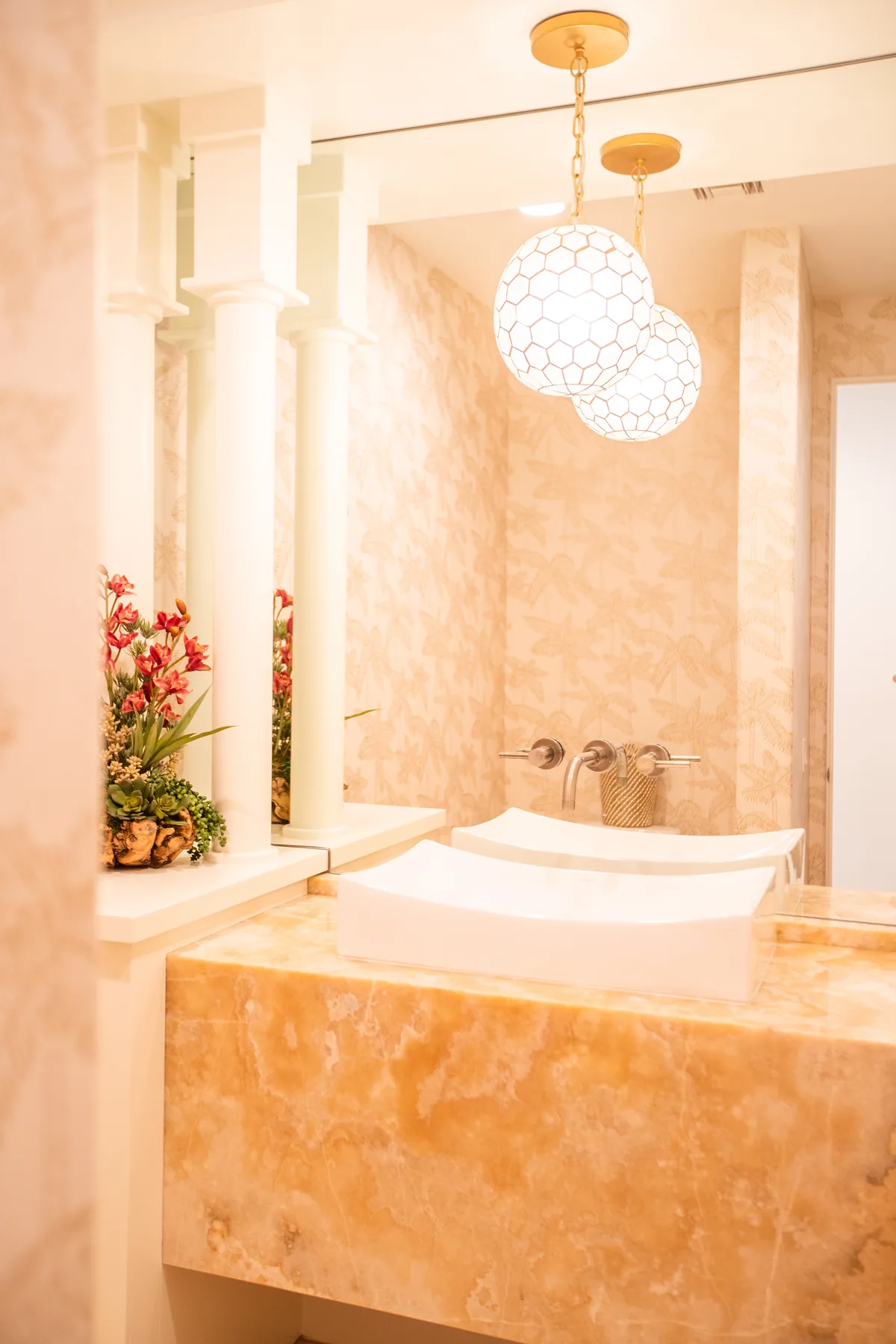Bathroom with an onyx-clad tub surround, arched alcove and a pair of globe pendants